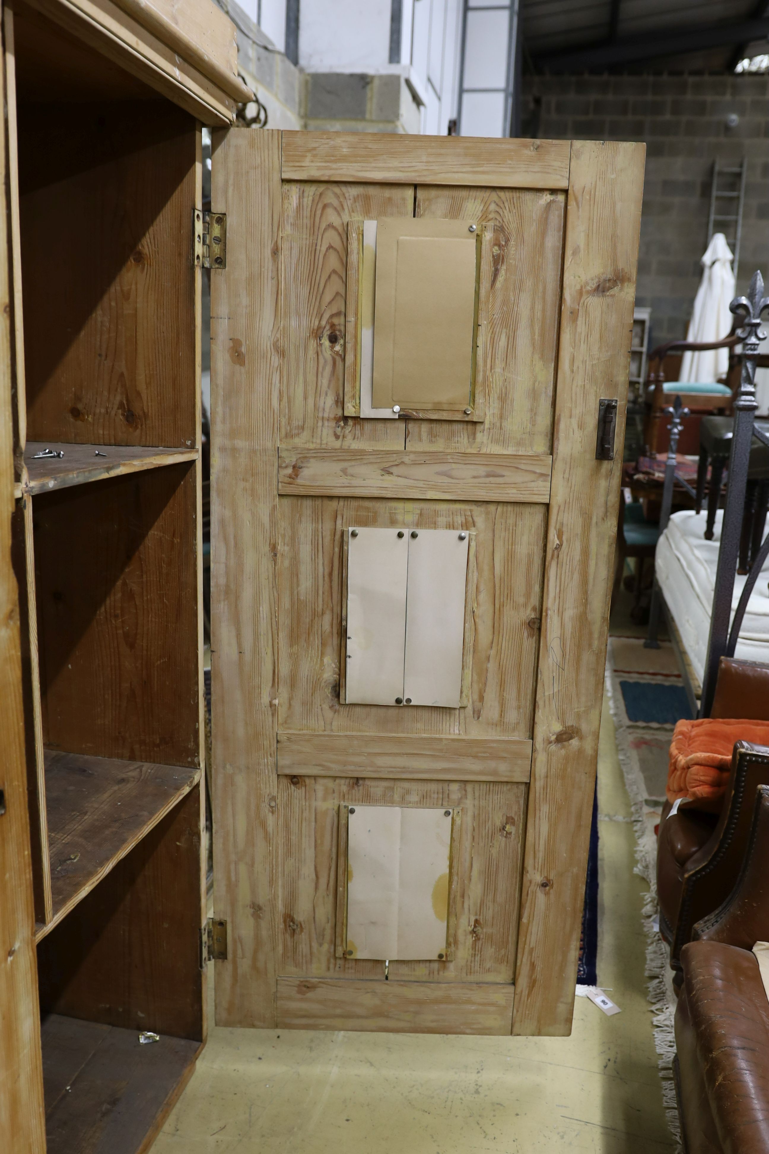 A 19th century stripped pine hall cupboard modelled as a dolls house the two door nine window facade enclosing a compartmented interior, width 182cm, depth 46cm, height 192cm